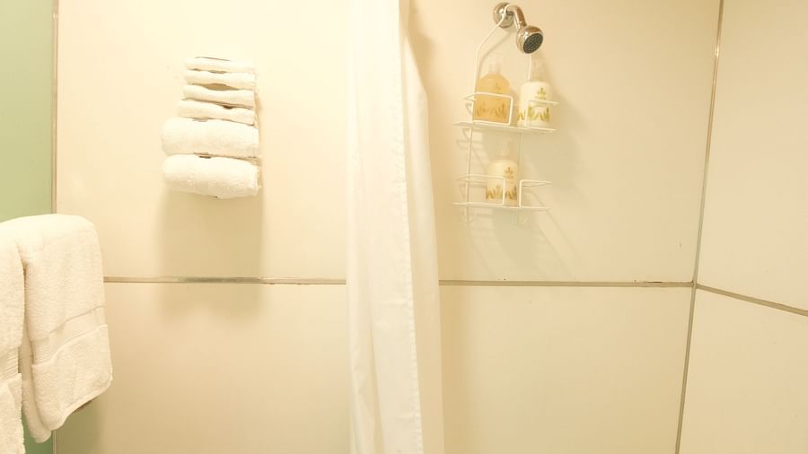a bright bathroom with a bath tub with a shower head above it - Historic Tapoco Lodge