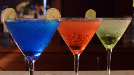 Three martini glasses with drinks and with twists