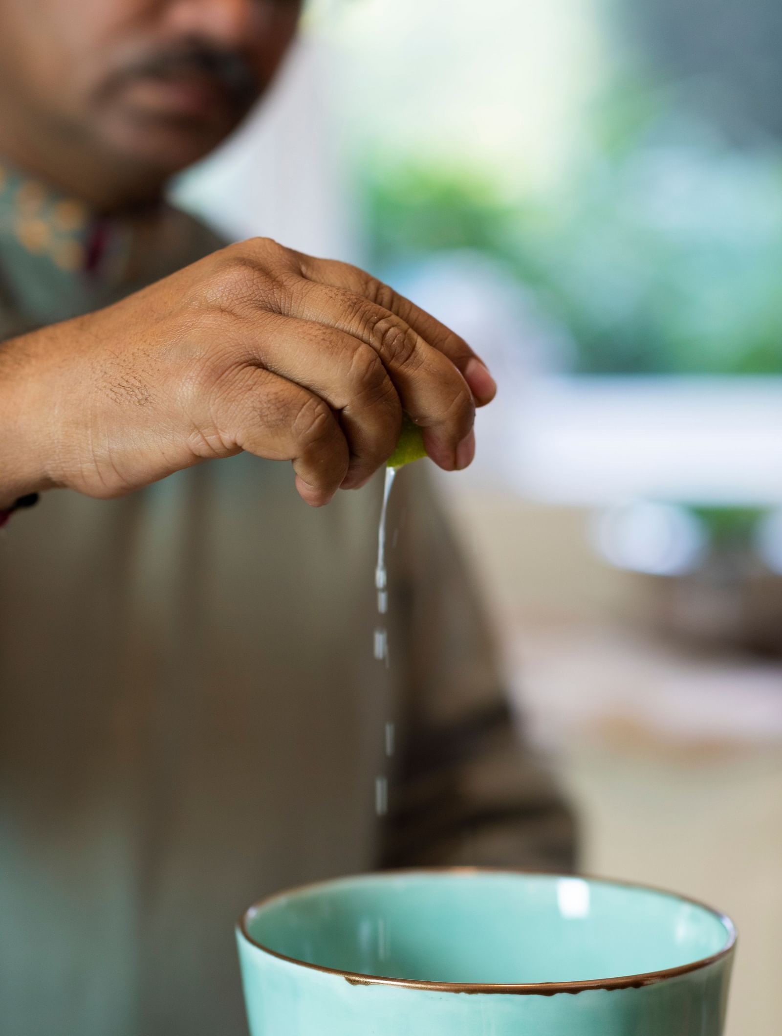 An image of a man squeezing lemon juice into a bowl.