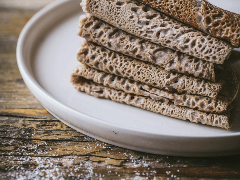 A plate kept on a table, filled with injera on top of each other, an Ethiopian traditional food