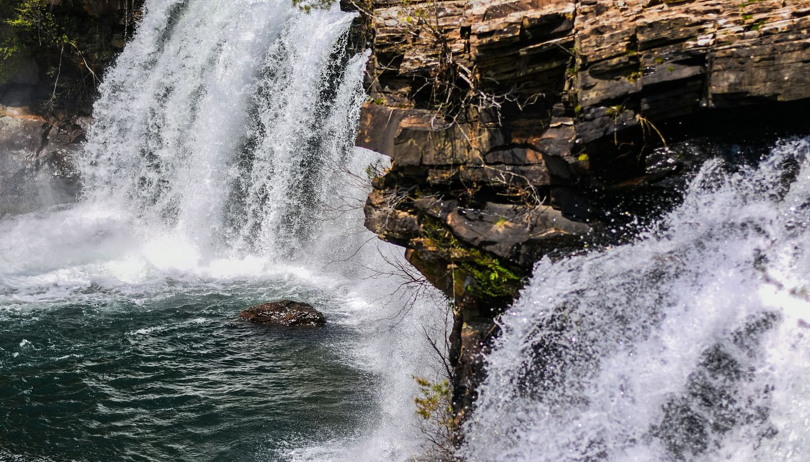 Waterfalls cascading through lush green forests, offering a serene and picturesque view