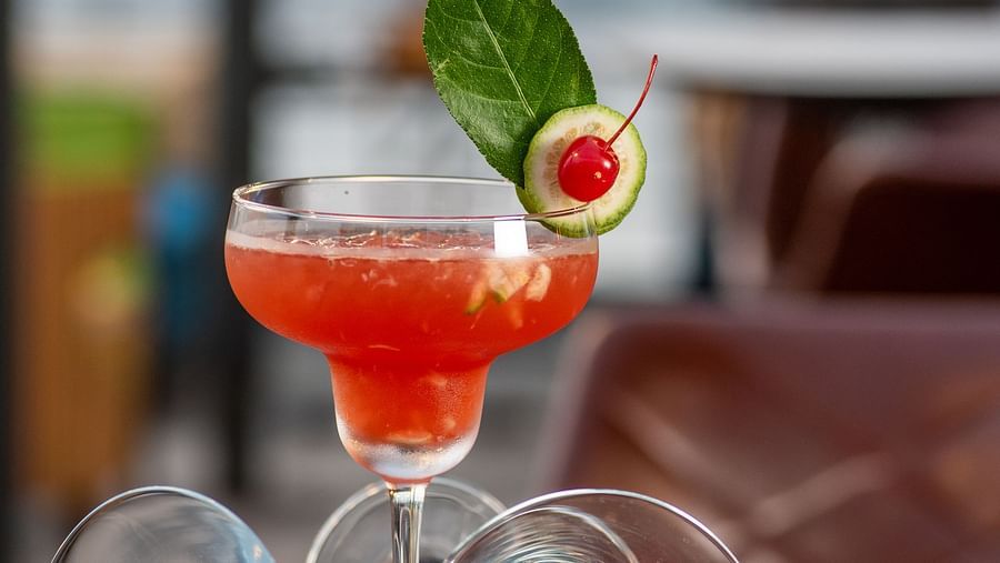 a glass of red drink kept on a table - polo floatel kolkata