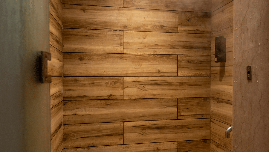 an image of a wooden finished steam room with a stool at DLS The Classio