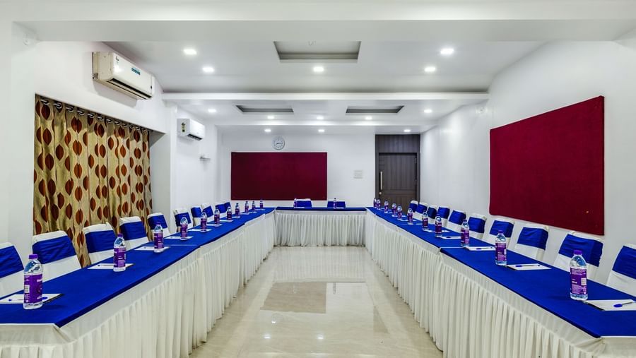 U-shaped seating arrangement with long tables and bright lighting at Emerald Retreat, Tungarli.