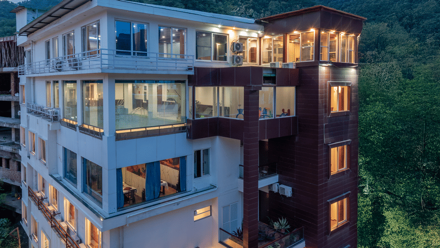 Exterior of DLS Hotels On The Ganges and hills in the background.