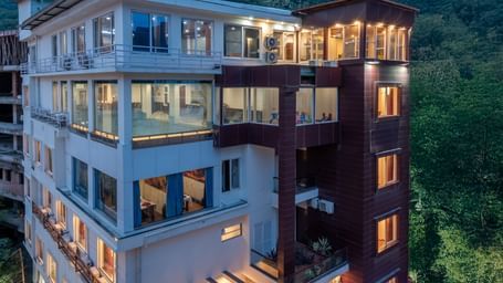 Exterior of DLS Hotels On The Ganges and hills in the background.