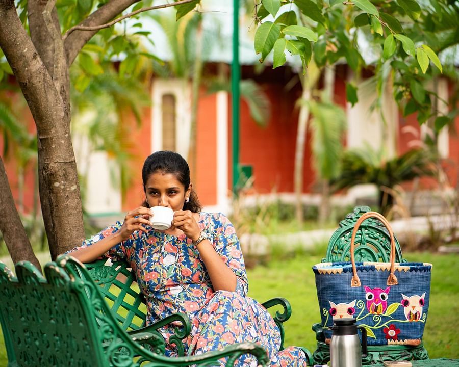 a woman having Tea in the lawn  - Ibex River Resort, Pollachi