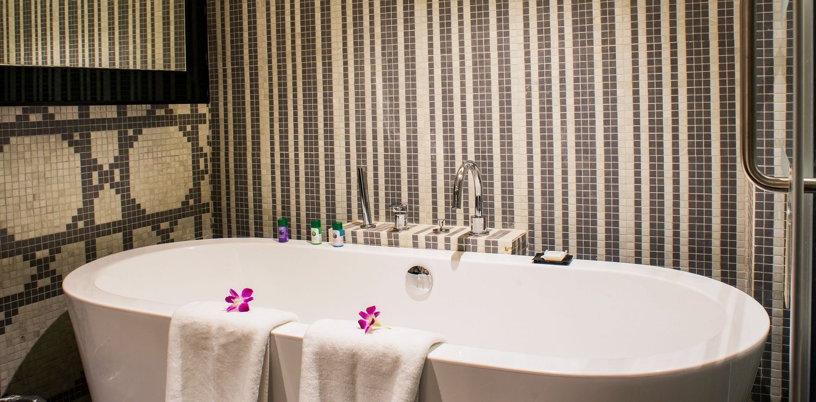 A shot of the bathtub with two towels at theme suite at Grand Chennai by GRT hotels.