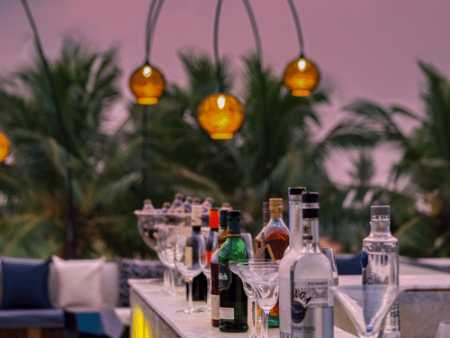 The outdoor dining area at the Lynx Restaurant, one of the best beach restaurants in South Goa, overlooking the pink-hued skies in the background.