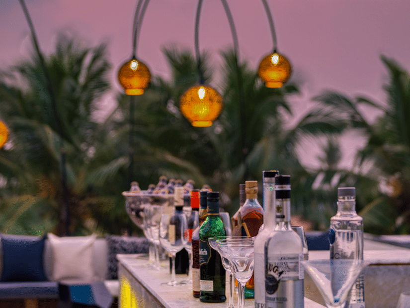 The outdoor dining area at the Lynx Restaurant, one of the best beach restaurants in South Goa, overlooking the pink-hued skies in the background.