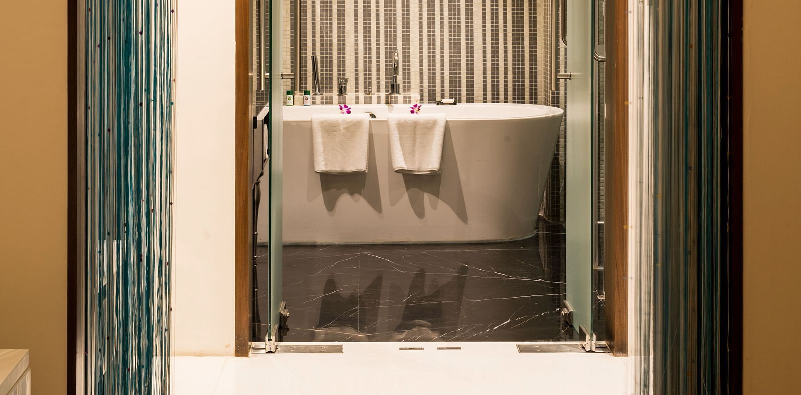 A shot of the theme suite bathroom featuring a bathtub and two towels at Grand Chennai by GRT hotels
