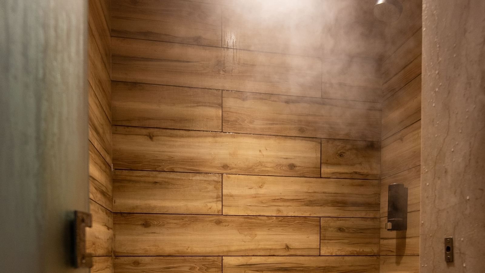 an image of a wooden finished steam room with a stool at DLS The Classio