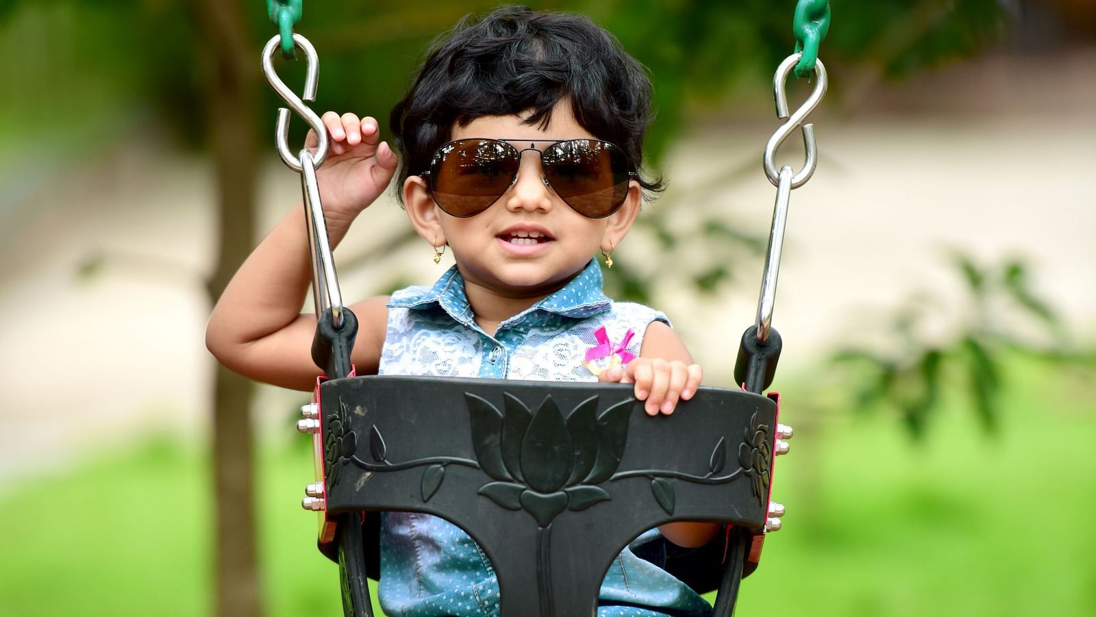 Image of a child sitting on a swing at Parampara Resort & Spa, Kushalnagar.