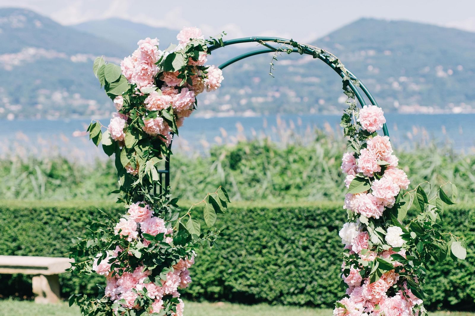 Floral arch with pink blooms against a mountain backdrop. | Vistar Resort, Bengaluru