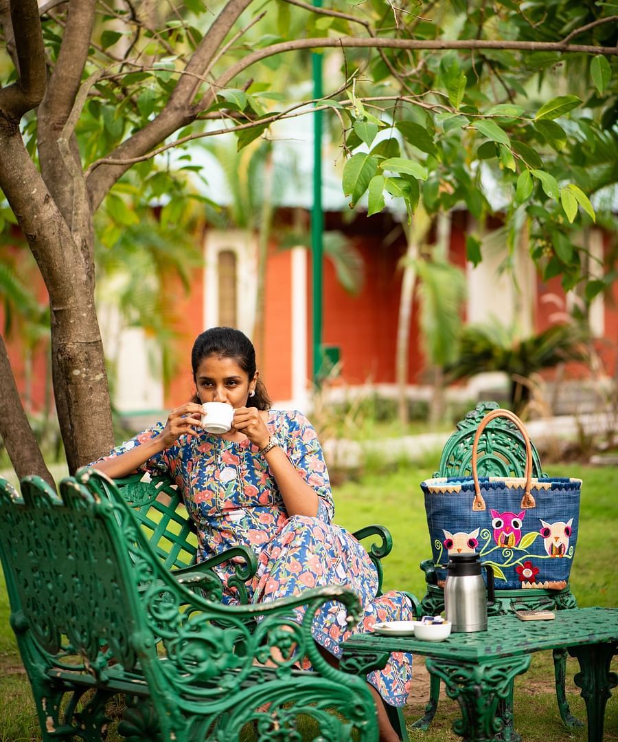a woman having Tea in the lawn  - Ibex River Resort, Pollachi