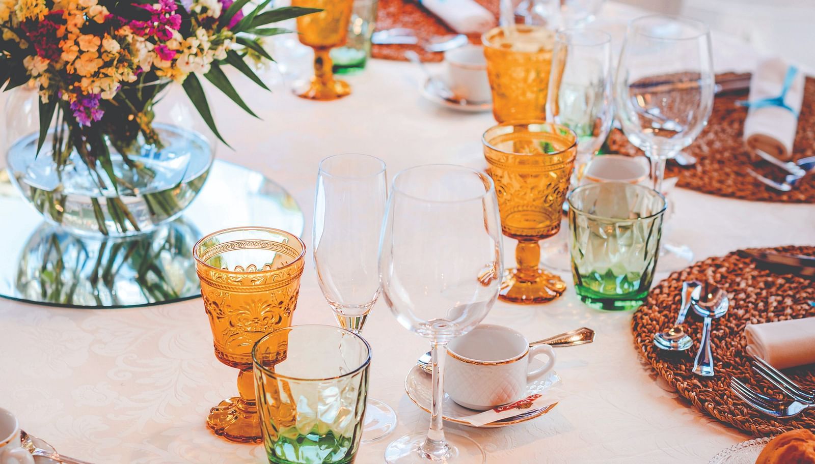 a table with glasses, bowls and a vase kept on it - Caravela Beach Resort Goa