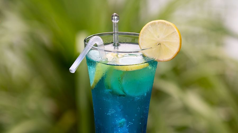 image of a blue refreshing cocktail filled with ice and topped with a lemon wedge
