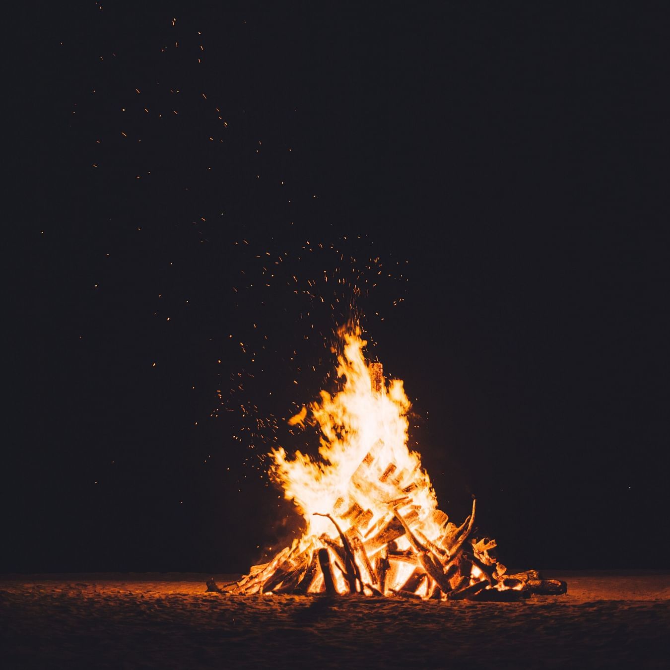A low angle shot of campfire flickering at night