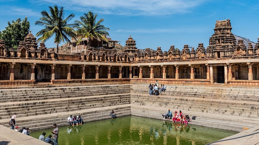 a view of people putting their feet inside the Tirupathi pond