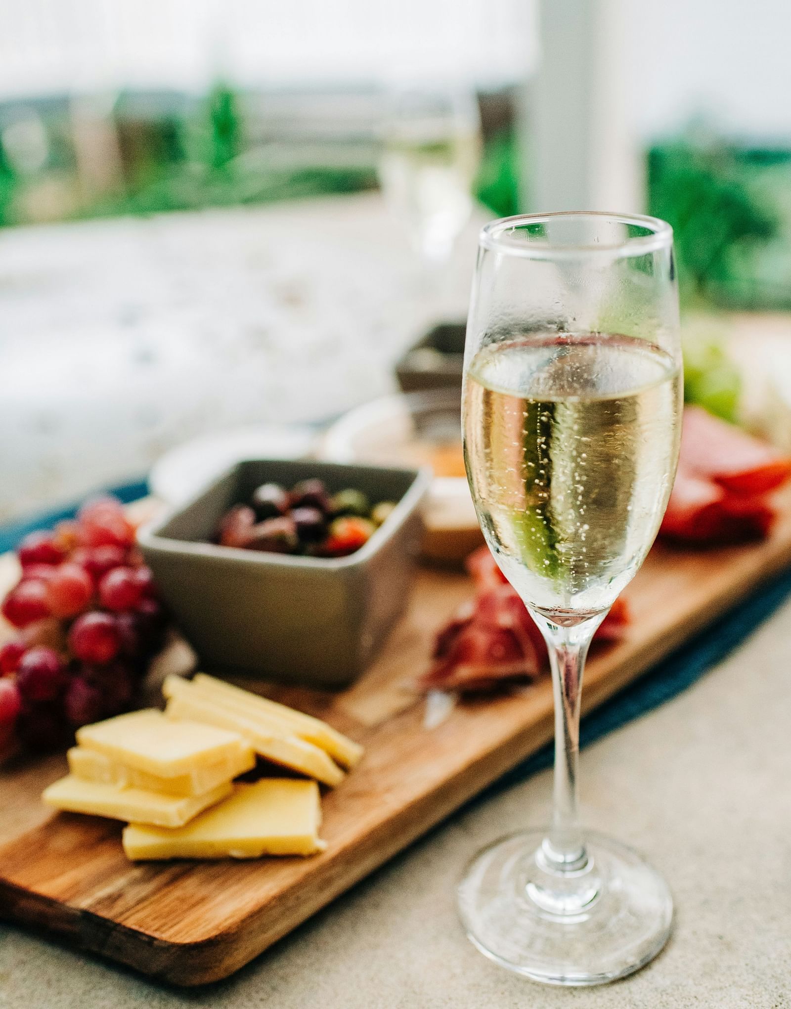 A flute of sparkling wine placed beside a fruit platter.