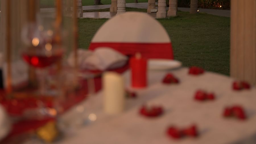 A beautifully set romantic dining table with a golden-lit gazebo in the background - Kaldan Samudhra Palace