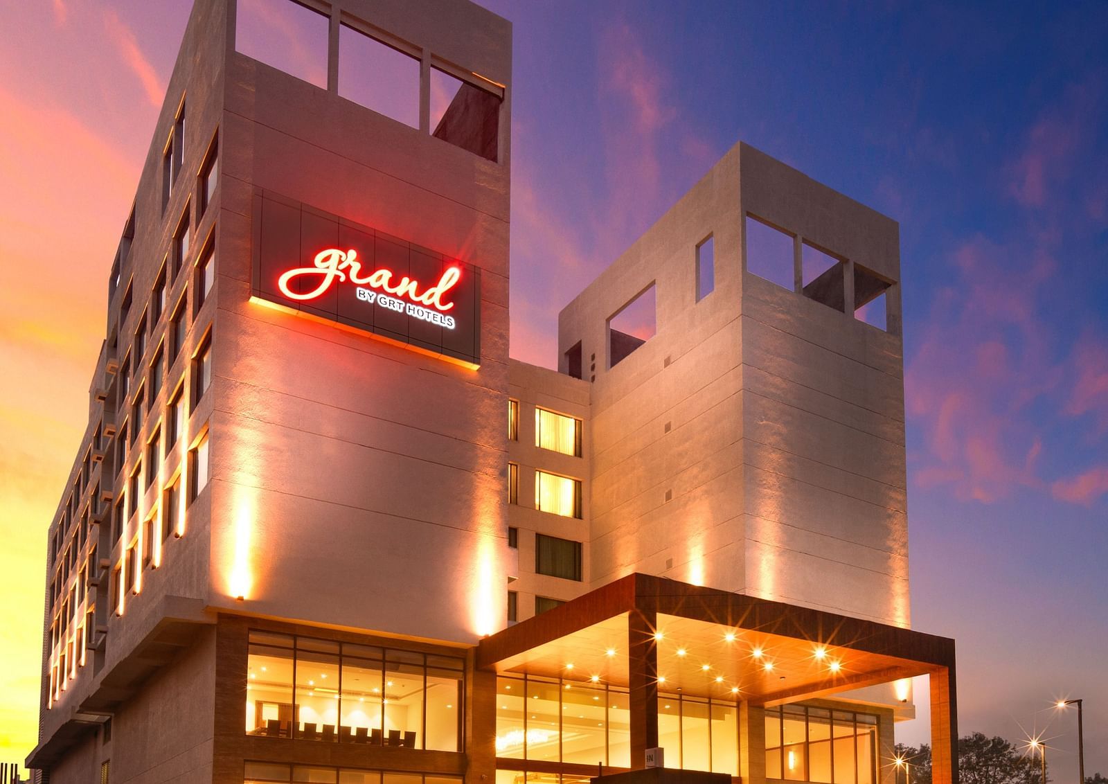 Facade image of Grand Vijayawada by GRT Hotels at dusk with warm golden lighting.