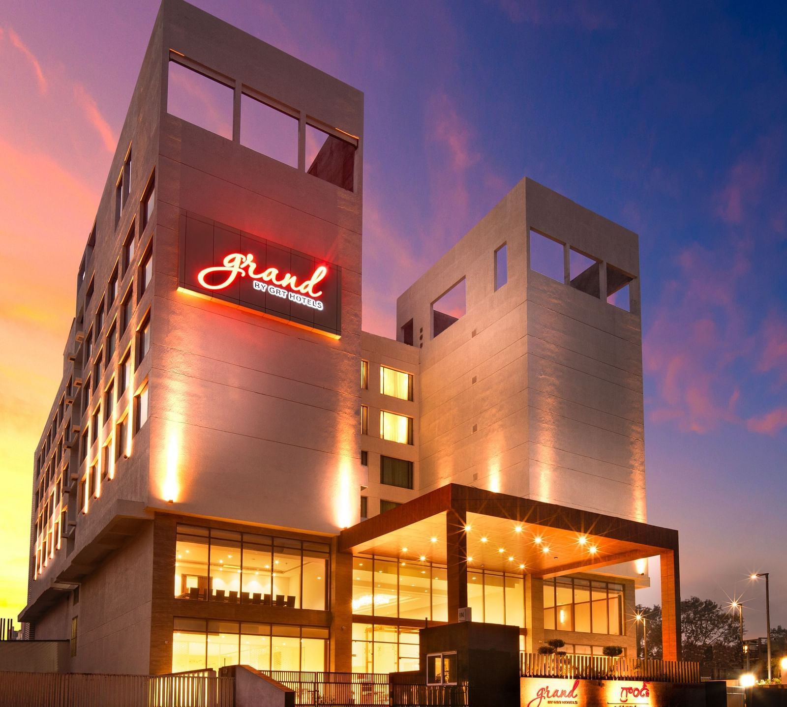 Facade image of Grand Vijayawada by GRT Hotels at dusk with warm golden lighting.