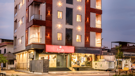 A multistory hotel building with a red and white sign on the roof.