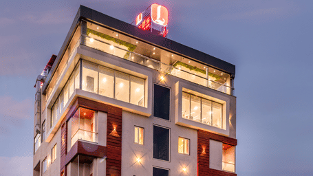  A multistory hotel building with a red and white sign on the roof.