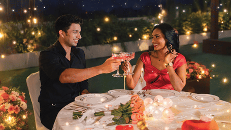 Promotional creative for The Starlit Valentine Dinner showcasing an elegant couple dining experience in a romantic starlit setting.
