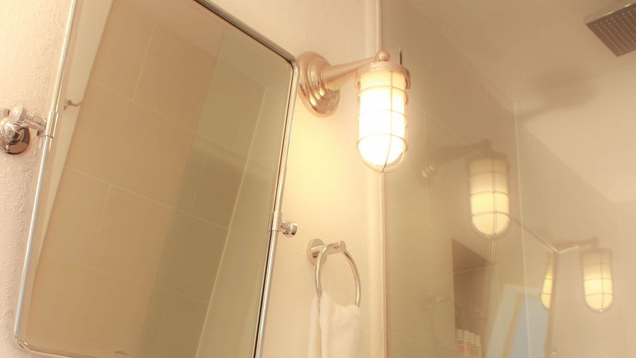 A well lit bathroom with a sink, mirror, and a walk in shower at Casa Morada.