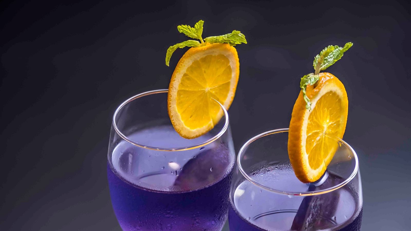 Image of butterfly pea flower tea in wine glass.