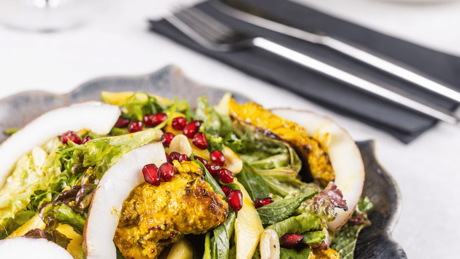 a dish garnished with pomegranate seeds and coconut shavings at Rosé