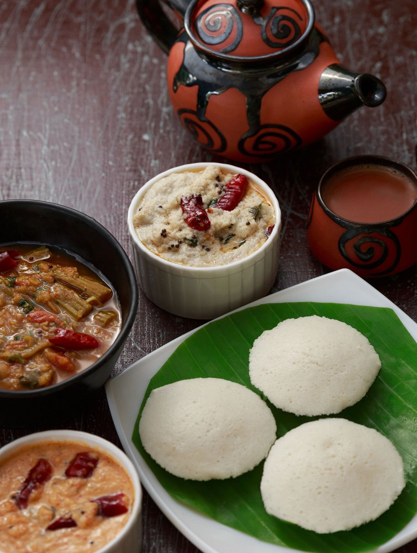 A top-down view of a plate with South Indian food, including what appears to be idli, sambar, and chutney.