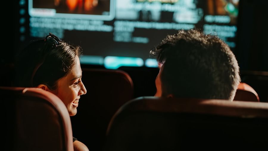 An over-the-shoulder view of a couple having fun and enjoying their movie time in the mini theatre at Crescent Spa & Resort, Indore