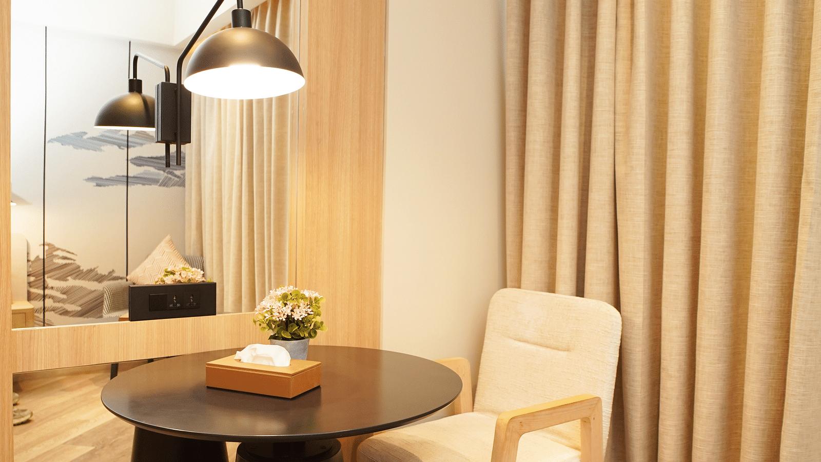 Table with two chairs near a window with curtains - Ramada Encore by Wyndham Gurugram Dwarka Expressway