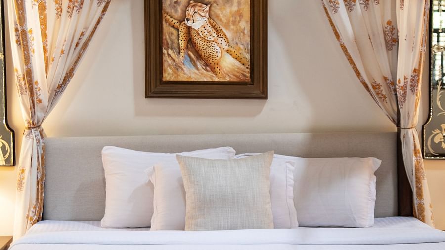clean white bed with beige curtains
