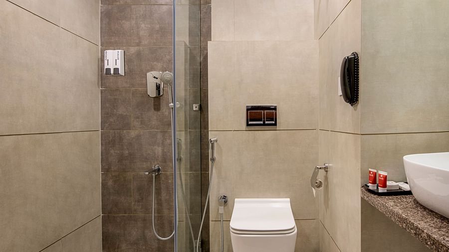 A compact hotel bathroom with a modern toilet and shower area, designed for functionality - SK Lords Inn Ahmedabad