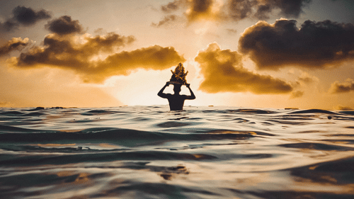 Silhouette Of Person In Water During Sunset