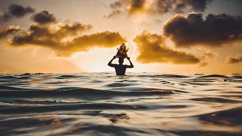 Silhouette Of Person In Water During Sunset