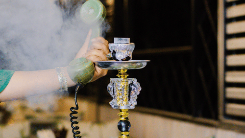 A hookah pipe being prepared at Hotel Polo Towers, with a cloud of smoke rising from the bowl.