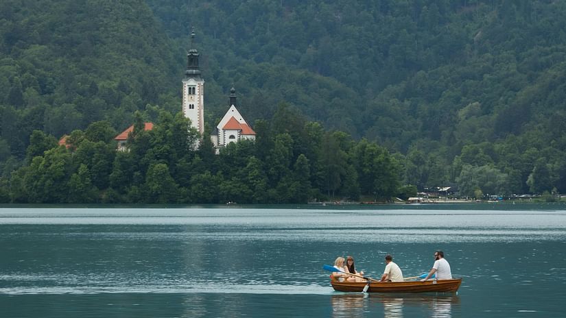image of a serene lake where people are sailing in a boat