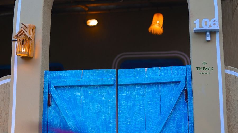semi arched gate with blue door at Themis Mudhouse - A Nature's Retreat Resort & Wellness