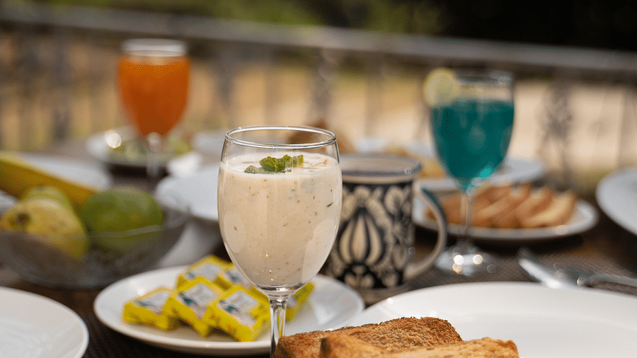 A close up shot of a drink placed along with various meals on the table at the Sylvan Retreat, Dehradun.