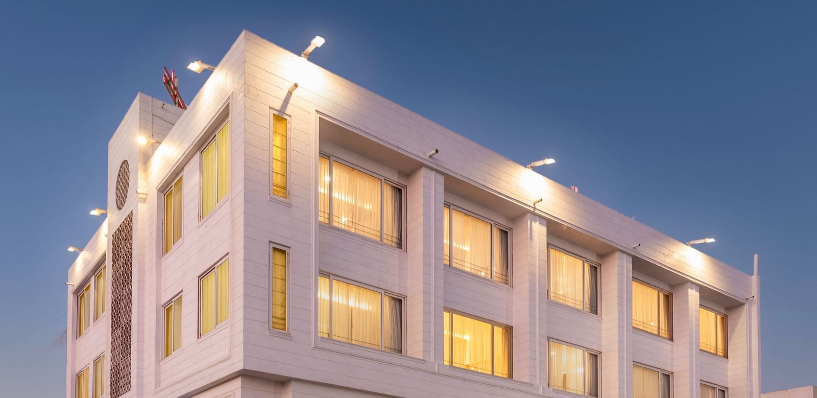 The illuminated facade of Dwarkadhish Lords Eco Inn at dusk.