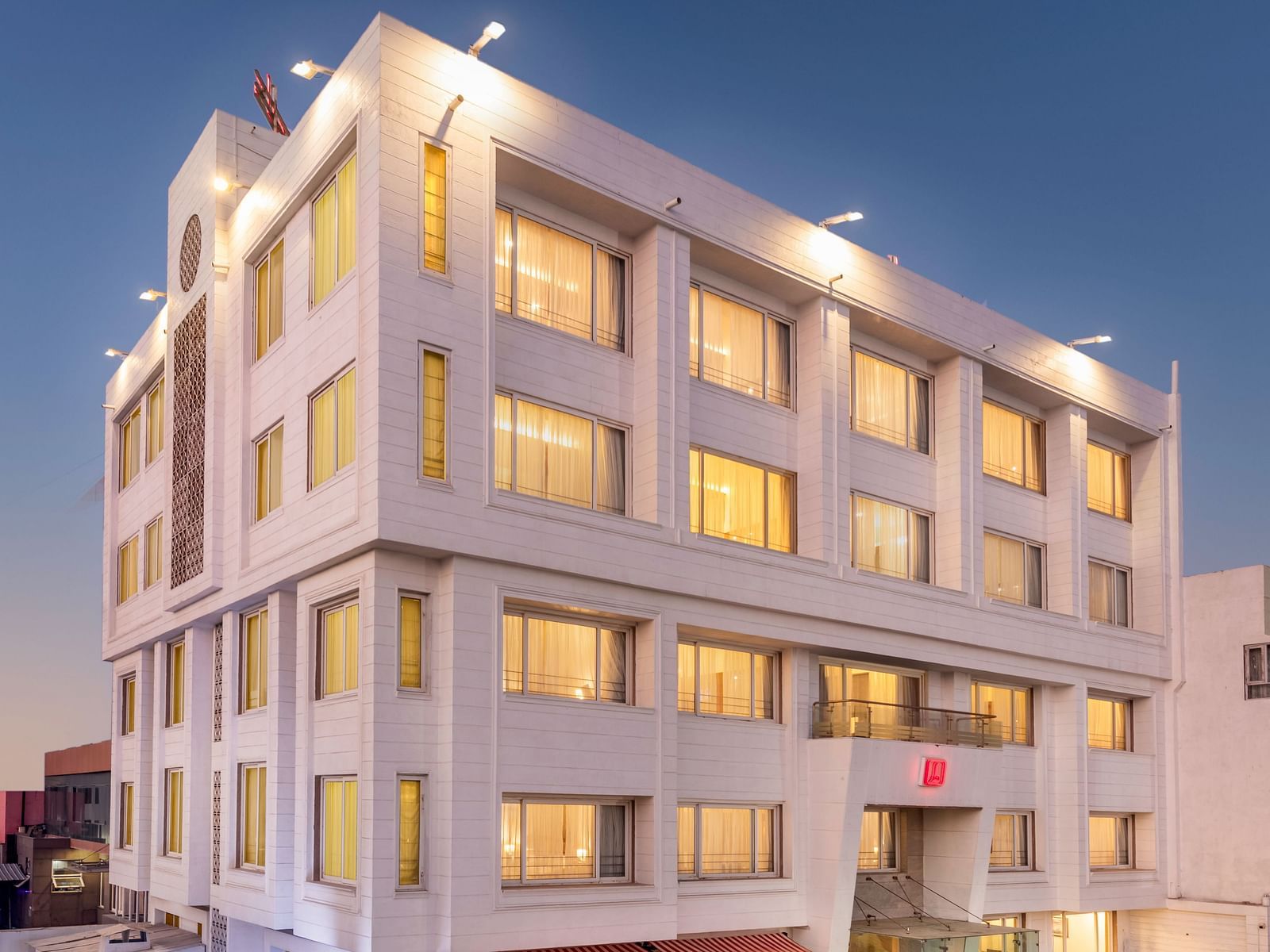 The illuminated facade of Dwarkadhish Lords Eco Inn at dusk.