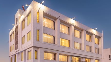 The illuminated facade of Dwarkadhish Lords Eco Inn at dusk.