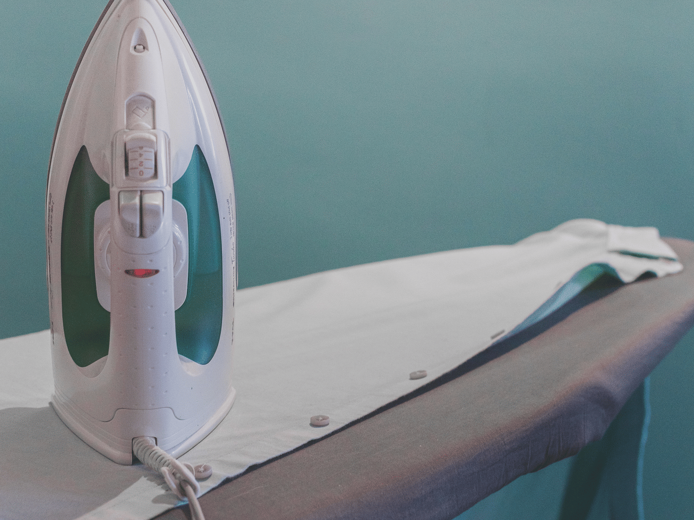 Ironing table with iron neatly arranged in the room for guest convenience.