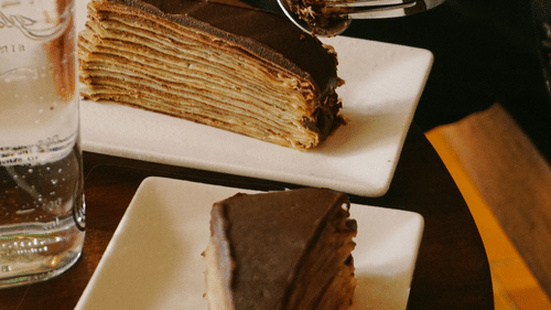 a person cutting in to a slice of cake