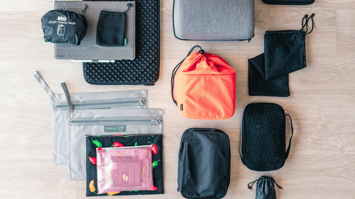 Bags and pouches placed together on a wooden table.